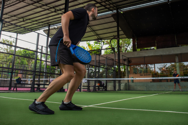 Padelspeler op een glazen padelbaan met focus op controle en anticipatie in 2026