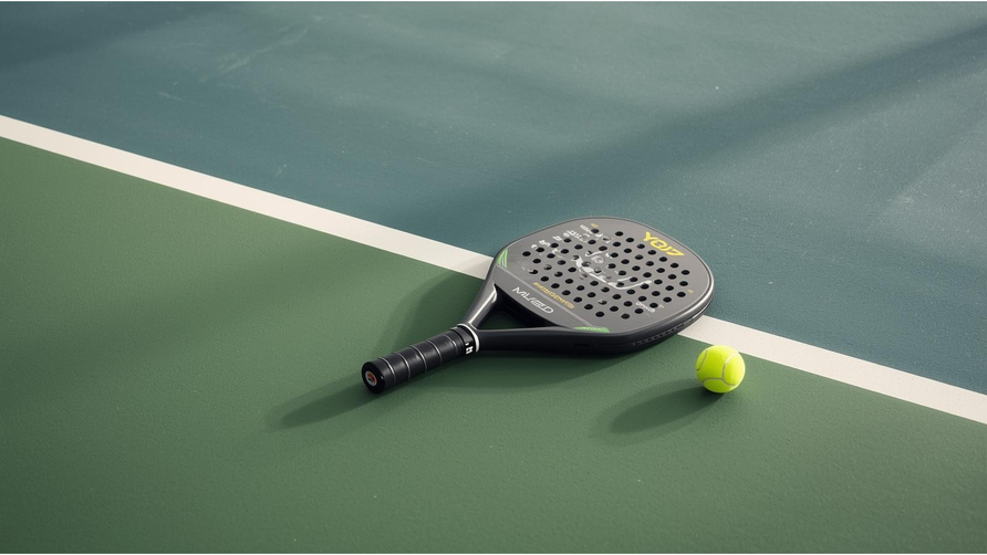 Rond padelracket met bal op padelbaan als beeld voor controle en precisie