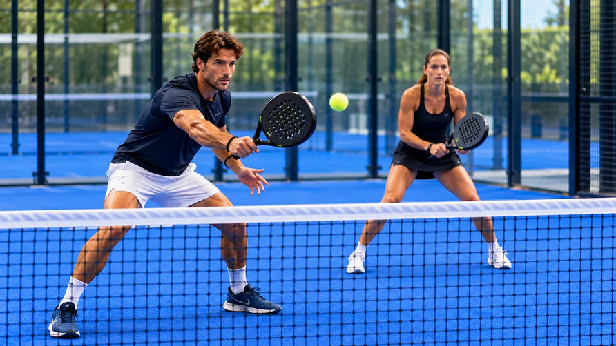 Padelspeler voert een gecontroleerde volley uit vlak bij het net, terwijl zijn dubbelpartner klaarstaat.